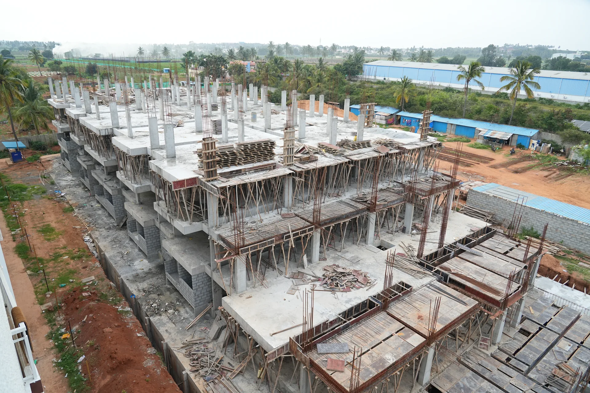 Elevated overview of columns, slabs and formwork across the Sapthagiri Sampada site